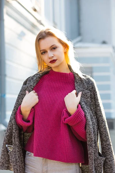 Elegant blonde woman wearing coat and sweater, posing with soft — Stock Photo, Image