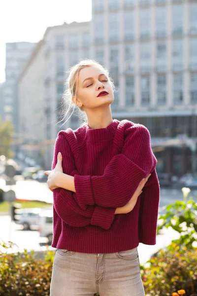 Lovely blonde woman wearing grey jeans and knitted sweater, posi — Stock Photo, Image
