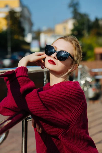 Romantic blonde lady wearing sweater and glasses posing at the c — Stock Photo, Image