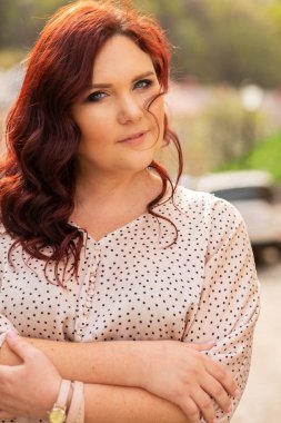 Güzel kırmızı saçlı orta yaşlı kadın bir kamera bakarak