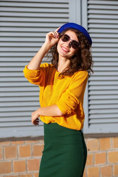 Pozytywny brunetka model z kręcone włosy noszenie okulary i styl — Zdjęcie stockowe