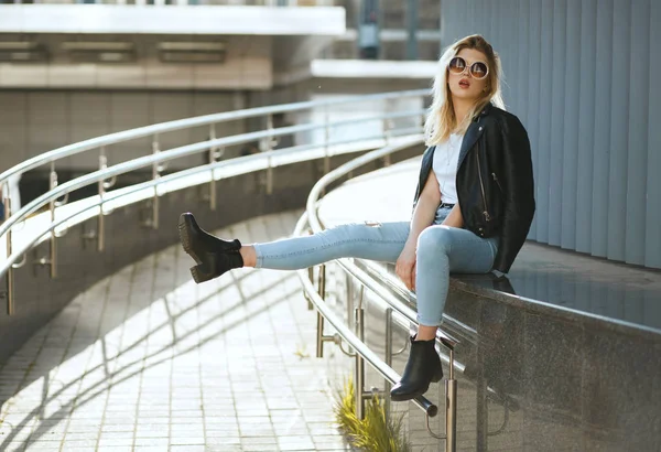 Fashionabla snygg kvinna bär jeans och jacka sitter på St — Stockfoto