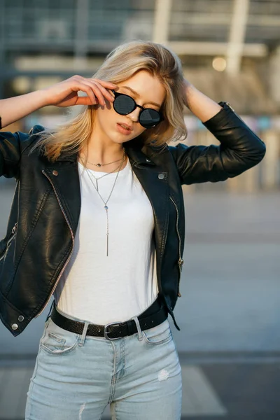 Street shot di giovane bella donna che indossa occhiali da sole e nero j — Foto Stock