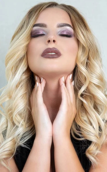 Mükemmel makyaj ve kıvırcık saçlı şehvetli genç kadın l giyiyor