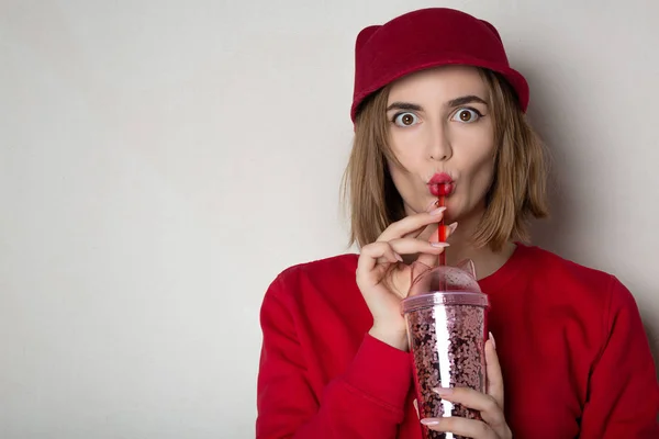 Verrast brunette vrouw in rode trui en Pet drinken Cherry — Stockfoto