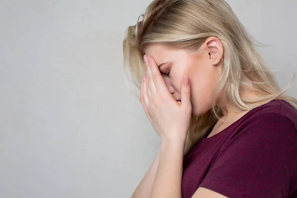 Depressieve huilen blonde vrouw bedekken haar gezicht met de handen. Space f — Stockfoto