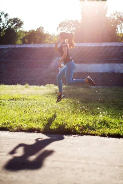 Stunning woman athlete in sport apparel jumping during the worko