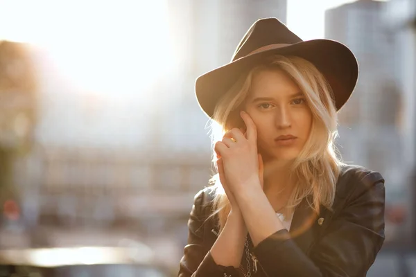 Pretty blonde woman wearing black hat posing with warm sun light — Stock Photo, Image