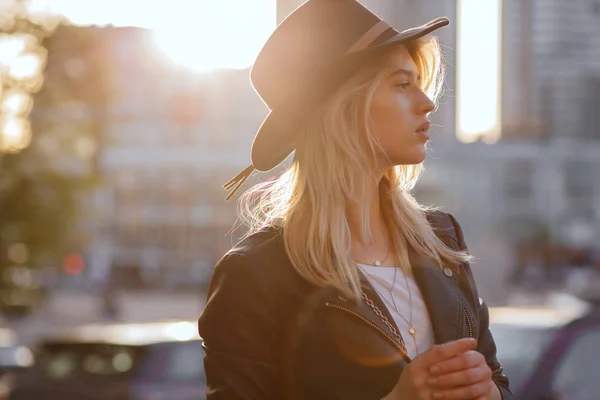 Lovely blonde woman wearing black hat posing with warm sun light — Stock Photo, Image