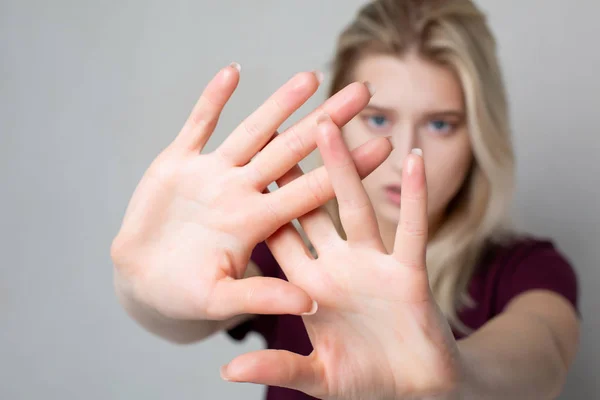 Jong blond meisje met stop gebaar over grijze muur. Ruimte voor — Stockfoto