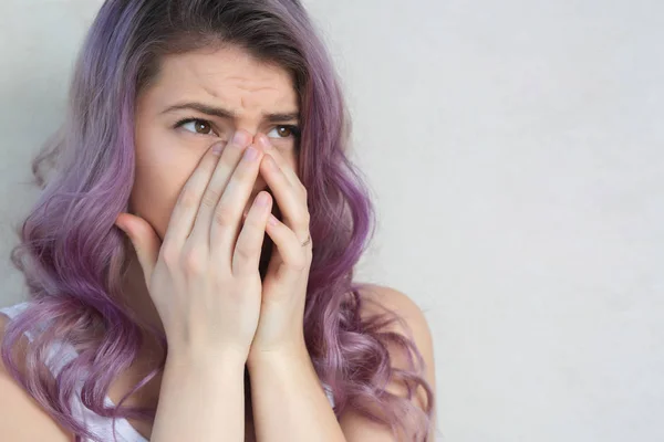 Troubled crying young woman covering her face with hands. Space