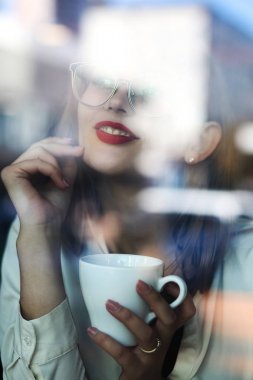 Sevimli genç model bir fincan ile restoranda vakit geçirmek 