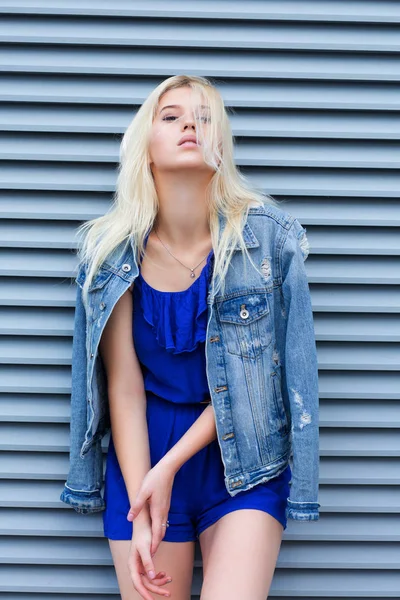 Стильная блондинка в модной одежде позирует рядом с мета — стоковое фото