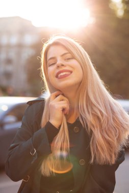 Şirin genç model ışınları yolda poz şık ceket giyiyor