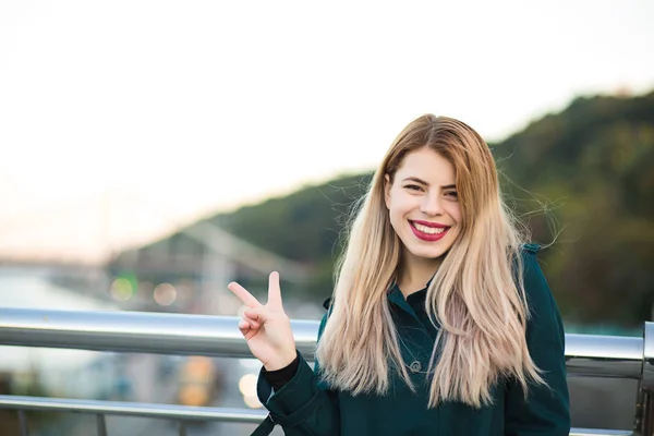 Lifestyle portrait: cute blonde girl with red lips showing peace — Stock Photo, Image