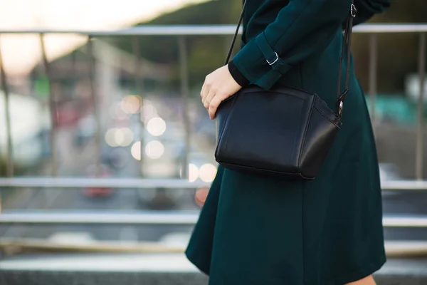 Moda vestido mulher segurando bolsa de couro no fundo de — Fotografia de Stock