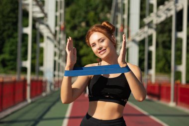 Mutlu sportif kadın kauçuk direnç ba ile el egzersiz yapıyor