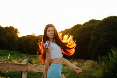 Doğada rahatlatıcı uzun saçlı çırpınan ile sevimli esmer kadın