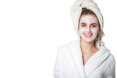 Üzerinde nemlendirici maske ve banyo havlusu ile mutlu esmer kadın
