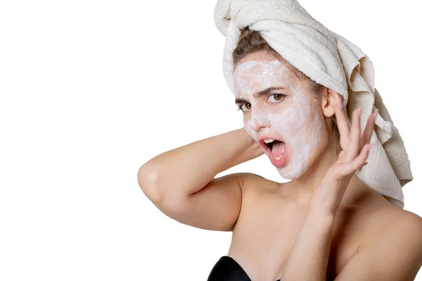Chica morena asustada con crema hidratante máscara y toalla de baño — Foto de Stock