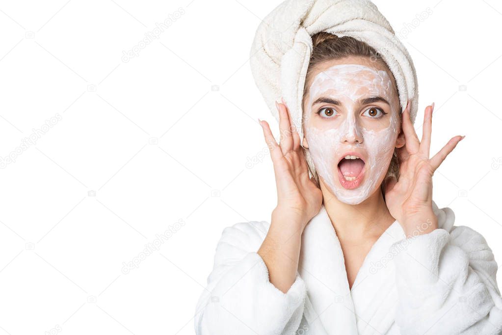 Excited brunette girl with moisturizing mask and bath towel on h