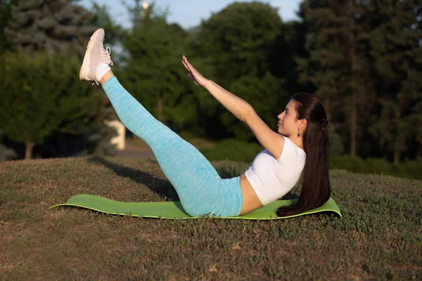 Young fit girl wearing sport apparel doing stretching workout at — Stock Photo, Image