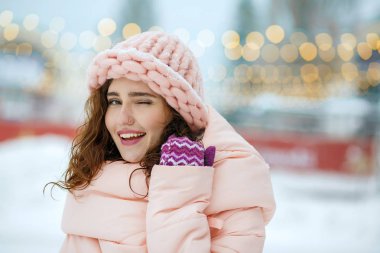 Örgü şapka lı göz kırpma giyen mutlu kız