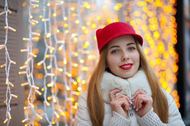 Çelenklere poz veren kırmızı dudaklı neşeli kadın