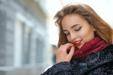 Şehirde yürüyen kırmızı dudaklı neşeli kız