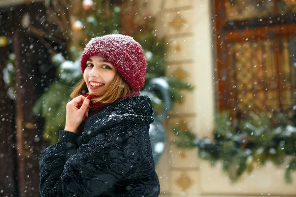 Menina encantadora vestindo boné vermelho apreciando queda de neve — Fotografia de Stock