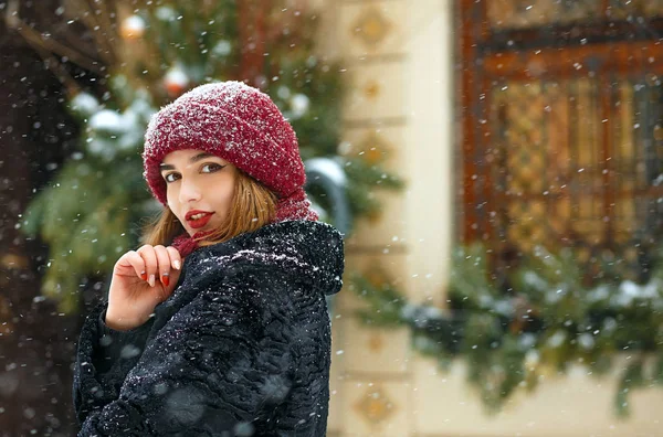 Прекрасная девушка с красными губами ходит во время снегопада — стоковое фото