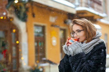 Kısa kıvırcık saç içecekler çay ile keyifli kız