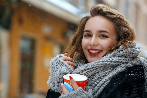 Positive girl with curly hair drinks cacao — Stock Photo, Image