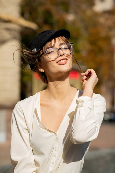 Menina agradável usa boné elegante e óculos — Fotografia de Stock