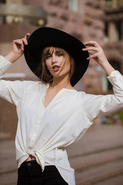 Femme élégante porte un chapeau noir marchant dans la rue — Photo