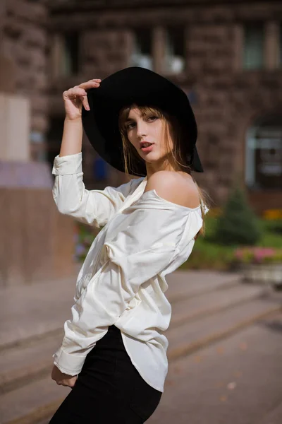 Belle femme porte un chapeau noir marchant dans la rue — Photo