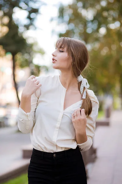 Elegant girl wears white blouse walks in the park Royalty Free Stock Photos