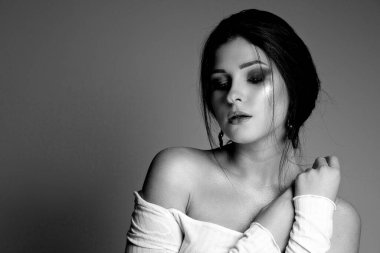 Stüdyoda çıplak poz veren şehvetli bir modelin siyah beyaz portresi. Boş boşluk