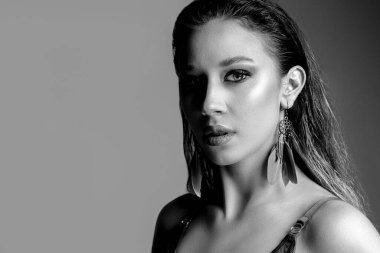 Stüdyoda çıplak poz veren göz kamaştırıcı bir modelin yakın plan siyah beyaz fotoğrafı. Metin için boşluk