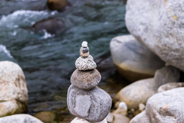 Rock Balancing: Stone Stacking Art having flowing river in the background