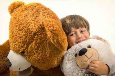 Küçük çocuk büyük ayılarla oynuyor.