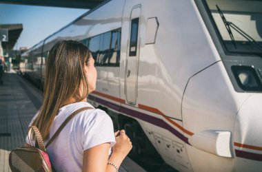 Kadın, tren istasyonunda treni bekliyor. Metroyu bekleyen bir kadının arka görüntüsü..