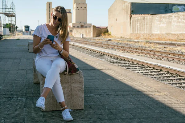 Young Woman On A Mobile Phone. Woman making a phone call while waiting for the train.