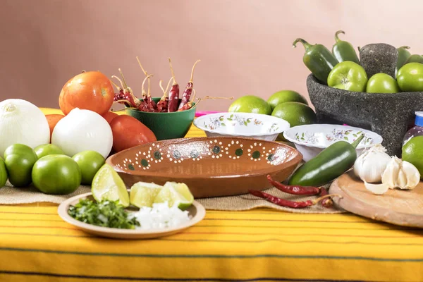 Typical Mexican food dishes with sauces on colorful table. Empty clay plate