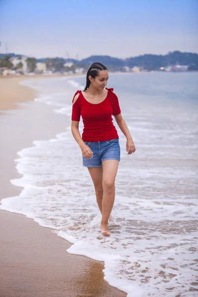 美丽的年轻女子在海滩上仰望大海 — 图库照片