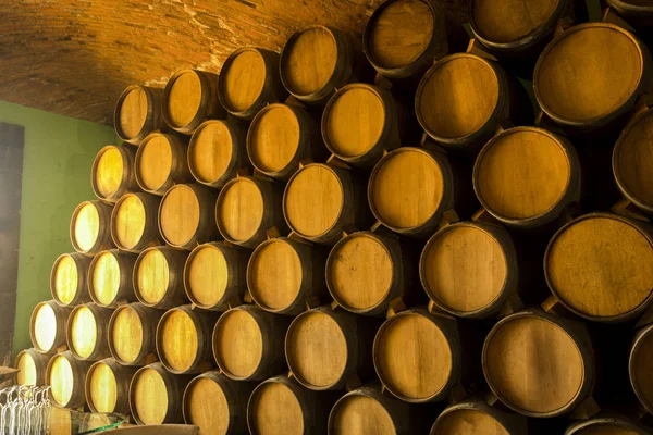 葡萄酒桶堆放在酿酒厂的旧地下室里 — 图库照片
