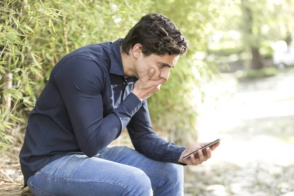 Jonge Onrustige Zakenman Zitten Tuin Met Mobiele Telefoon Zijn Hand — Stockfoto