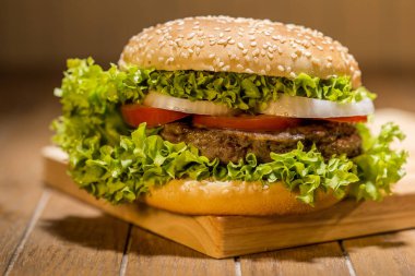 Ahşap tahta üzerinde sebze ile lezzetli hamburger