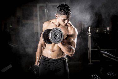 Genç adam karanlık ve yaşlı spor salonunda egzersiz yapıyor.