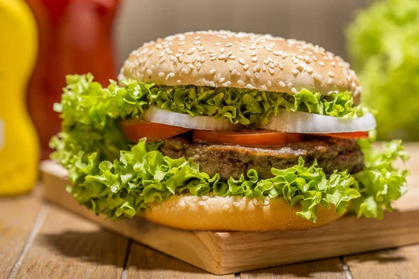 Ahşap tahta üzerinde sebze ile lezzetli hamburger